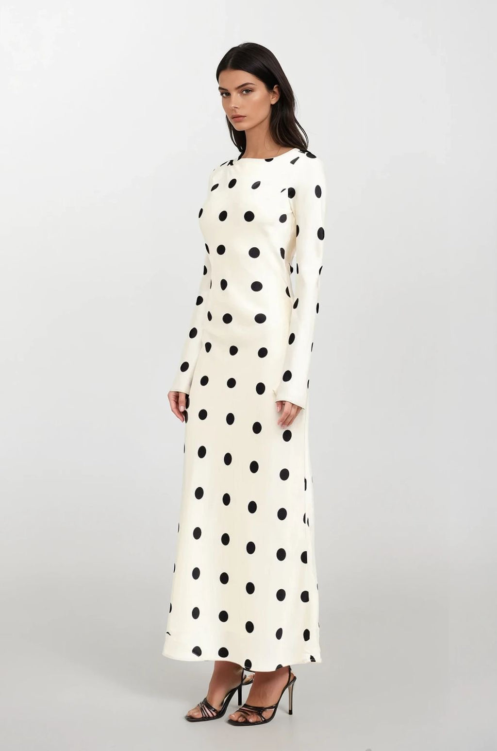 Woman wearing a long-sleeve polka dot dress on a white background