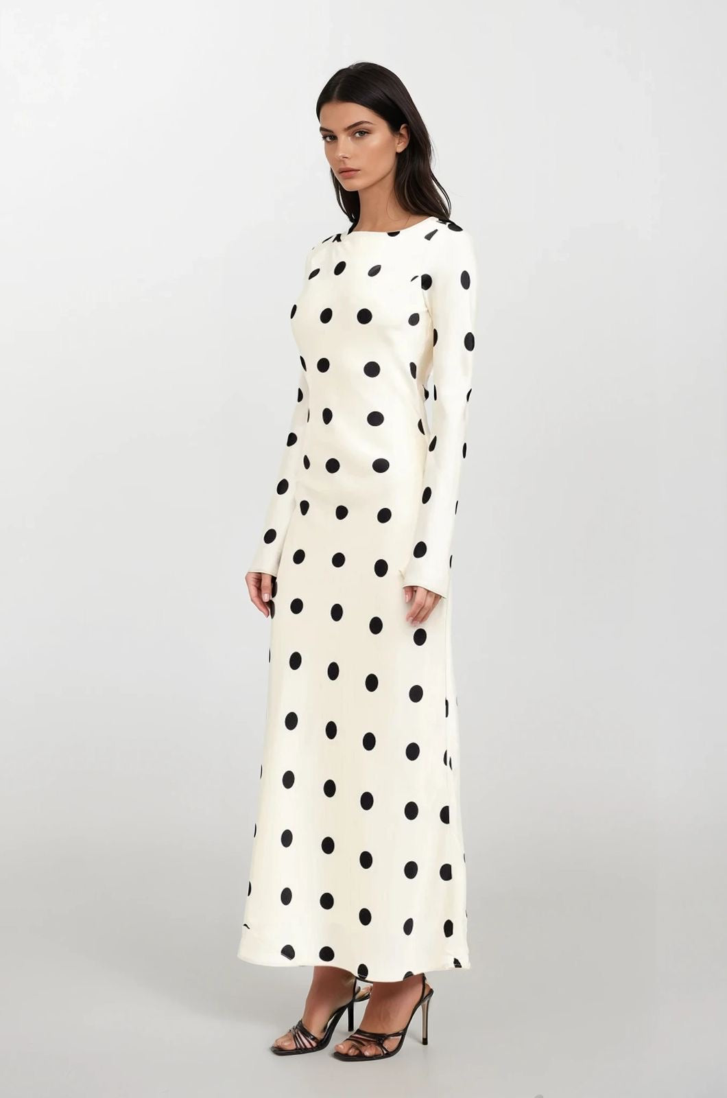 Woman wearing a long-sleeve polka dot dress on a white background
