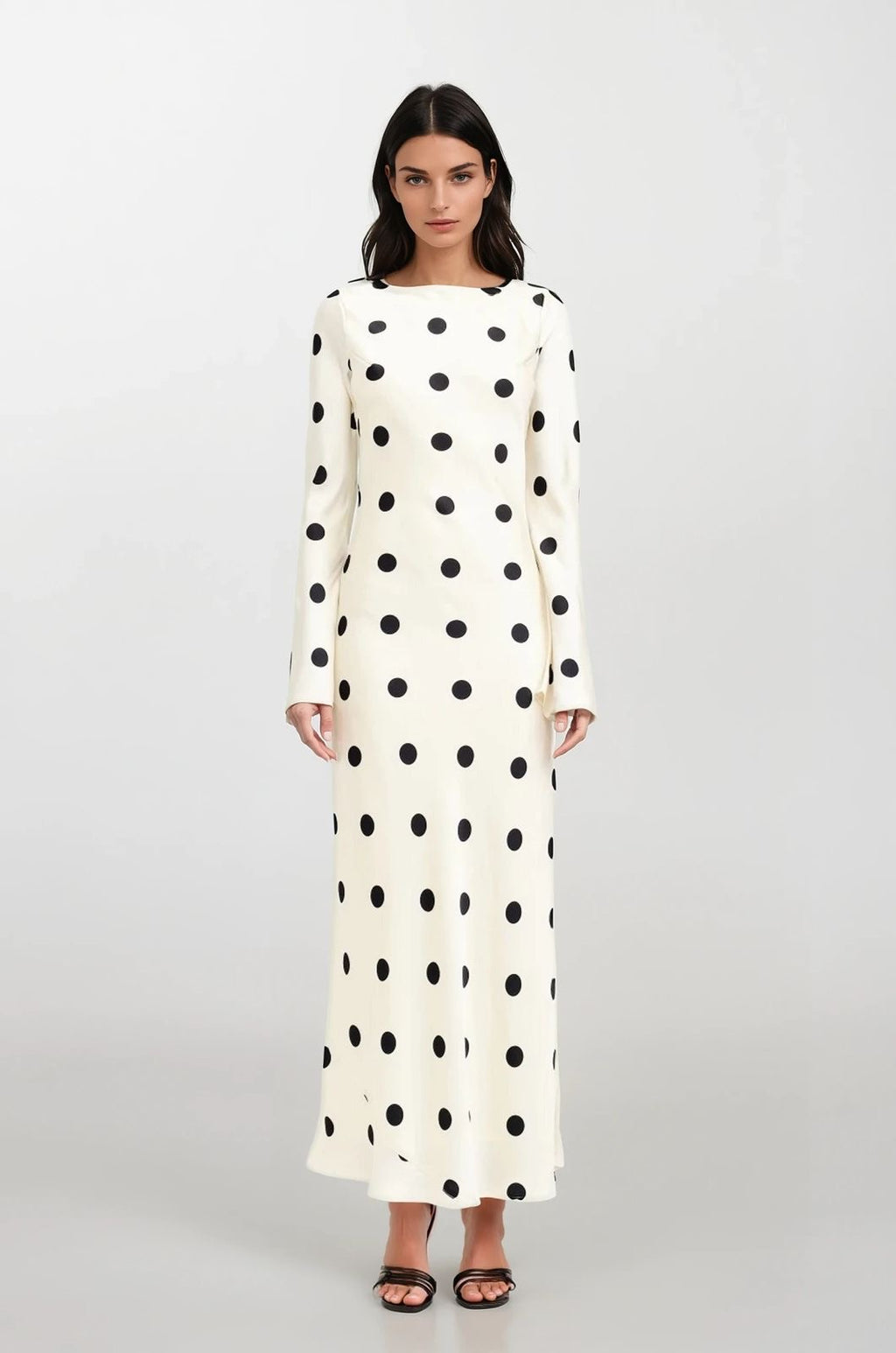 Woman wearing a long polka dot dress on a white background