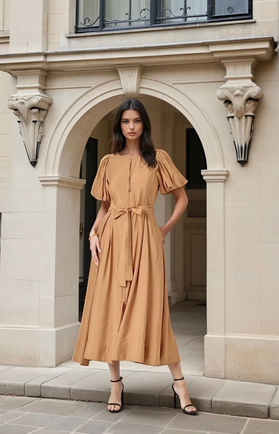 Woman in a beige dress standing in an archway of a building
